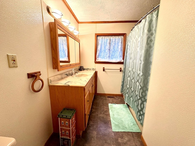 bathroom with crown molding, vanity, and a textured ceiling