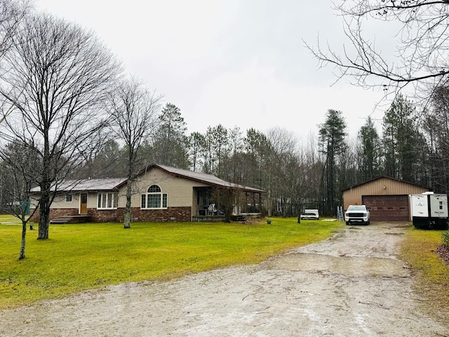 view of front of home with a front yard, an outbuilding, and a garage