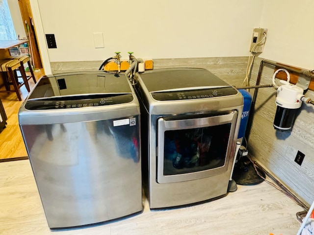 clothes washing area featuring washer and dryer and wood-type flooring