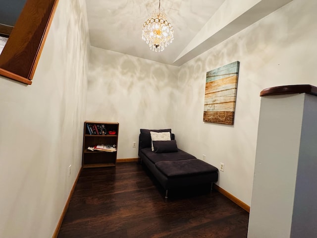 sitting room with a chandelier, dark hardwood / wood-style flooring, and lofted ceiling