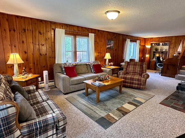 carpeted living room featuring a textured ceiling, baseboard heating, and wooden walls