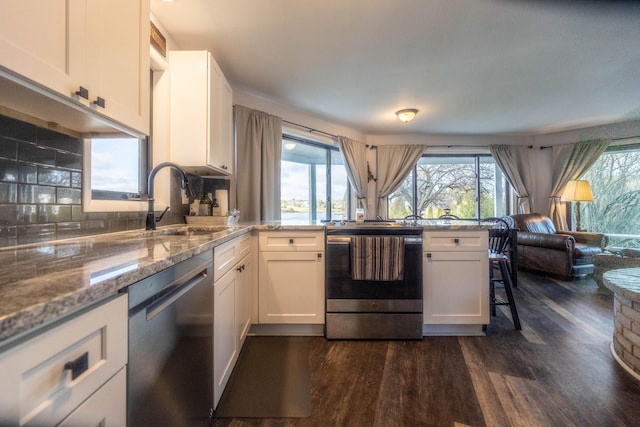 kitchen featuring light stone counters, stainless steel appliances, sink, white cabinets, and dark hardwood / wood-style floors