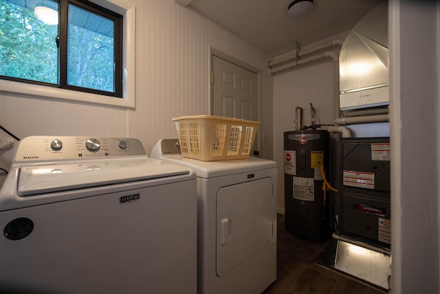 washroom with washing machine and dryer, dark hardwood / wood-style floors, and water heater