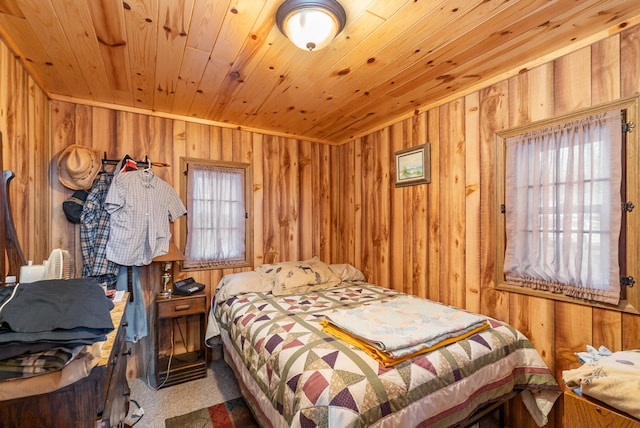 carpeted bedroom with multiple windows, wood walls, and wooden ceiling