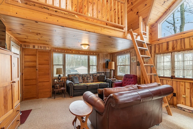 carpeted living room featuring vaulted ceiling, wooden walls, and wood ceiling