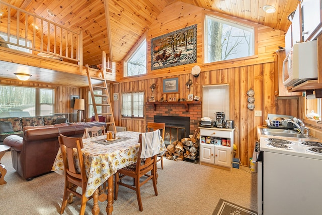 dining space featuring high vaulted ceiling, a healthy amount of sunlight, and light colored carpet