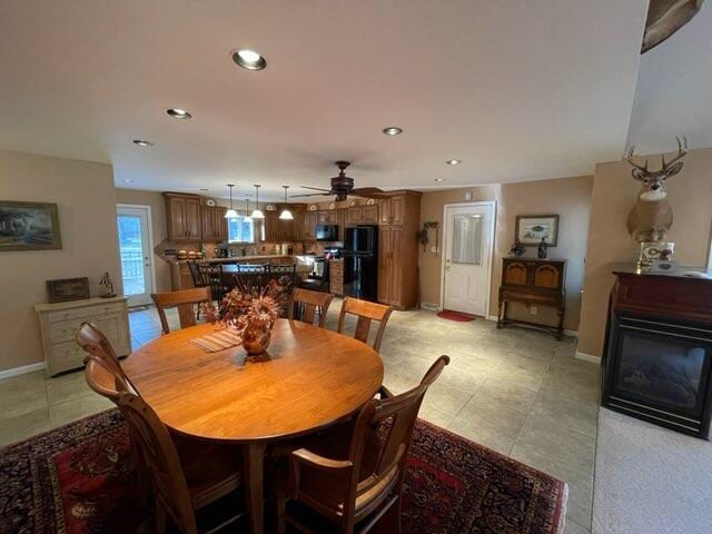 tiled dining space with ceiling fan