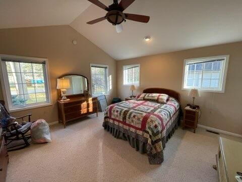 carpeted bedroom with multiple windows, ceiling fan, and lofted ceiling