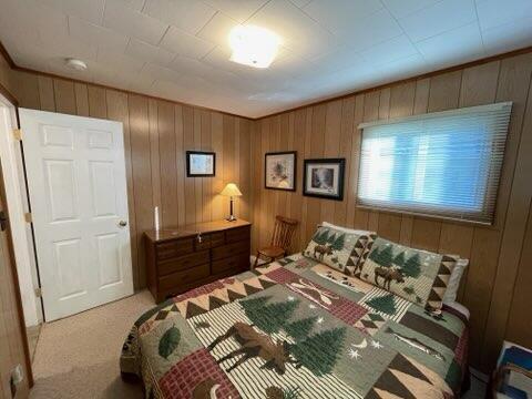 carpeted bedroom with wood walls