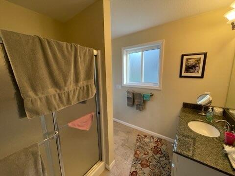 bathroom with vanity and a shower with door