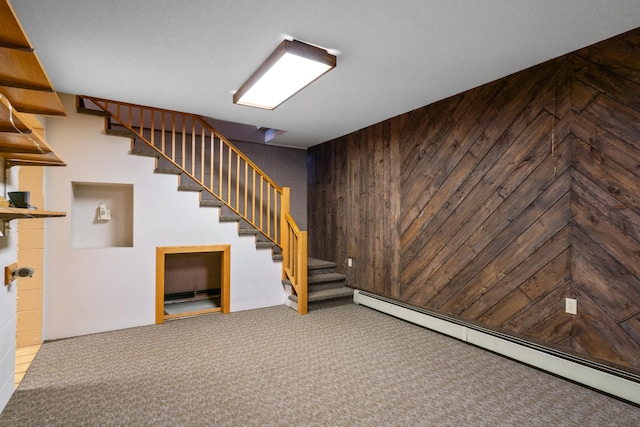 basement with carpet flooring, wooden walls, and a baseboard heating unit