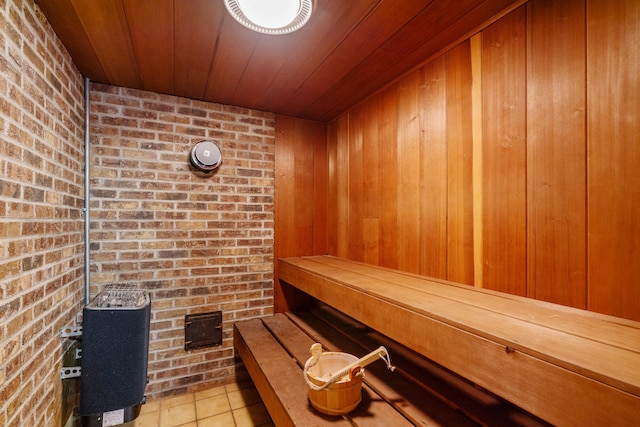 view of sauna featuring tile patterned floors and brick wall