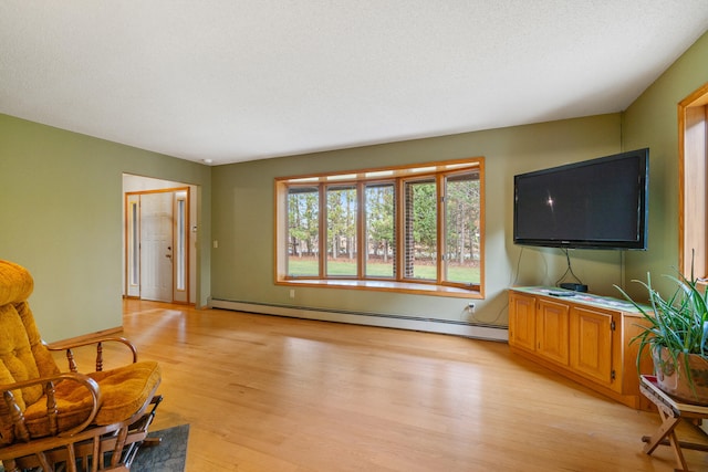 living room featuring a textured ceiling, light wood-type flooring, and a baseboard radiator