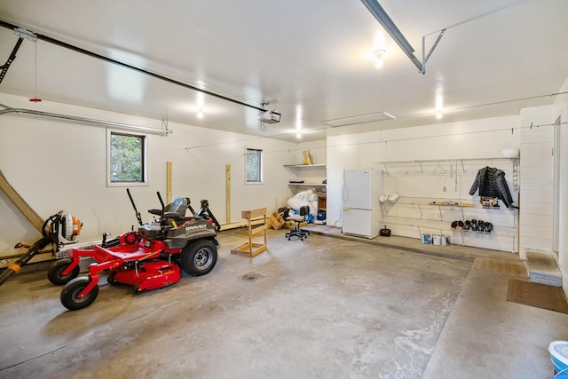 garage featuring white refrigerator and a garage door opener