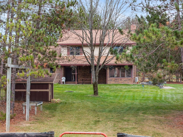 rear view of house featuring a yard and a sunroom