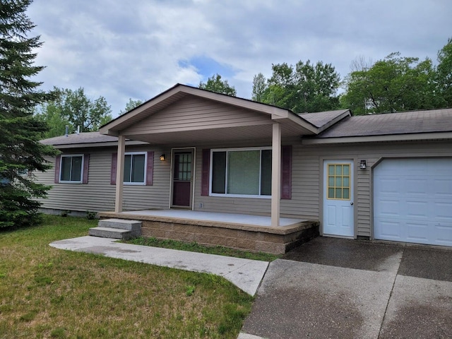 single story home with a front lawn, covered porch, and a garage