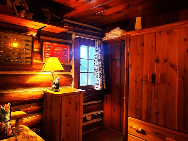 interior space featuring log walls and wooden ceiling