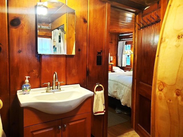 bathroom with vanity, wood ceiling, and wooden walls