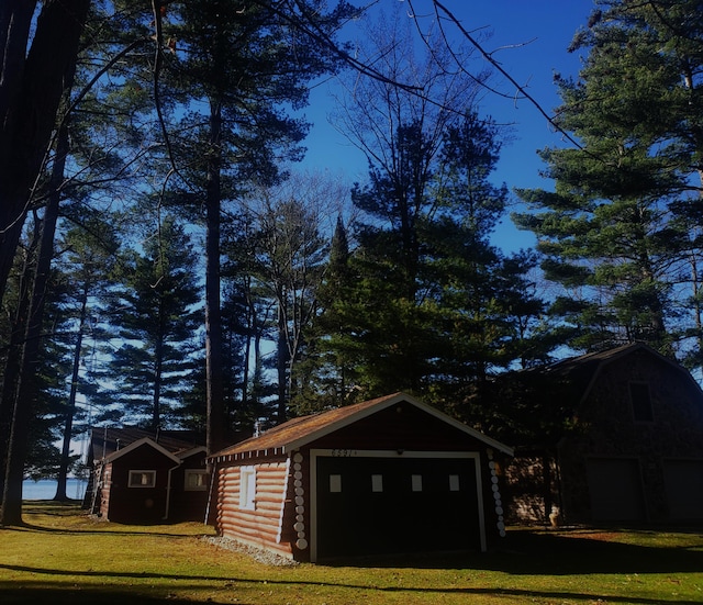 view of outdoor structure with a lawn and a garage