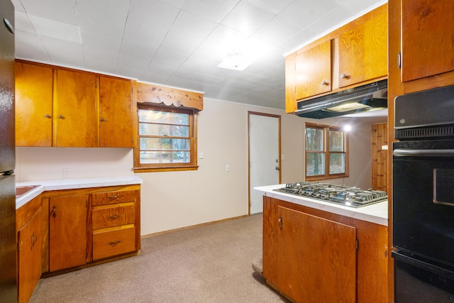 kitchen with black oven, plenty of natural light, light colored carpet, and stainless steel gas stovetop