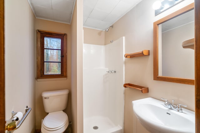 bathroom with toilet, walk in shower, ornamental molding, and sink