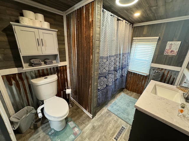 bathroom featuring wooden walls, toilet, vanity, and hardwood / wood-style flooring