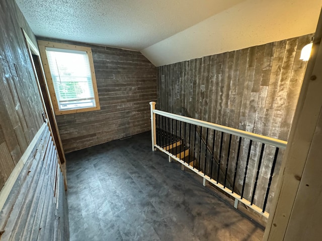 additional living space with a textured ceiling and lofted ceiling