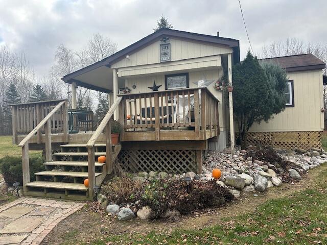 rear view of property featuring covered porch and a deck