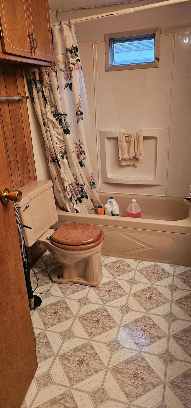 bathroom featuring shower / bath combination with curtain and toilet