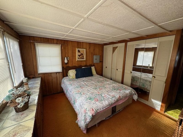 bedroom with carpet flooring and wooden walls