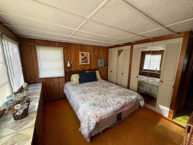 bedroom with wood walls, a closet, and carpet floors