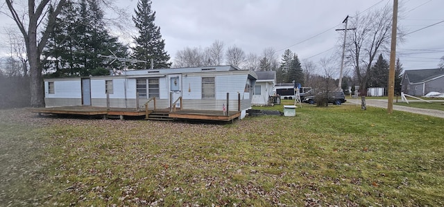 rear view of property featuring a deck and a yard