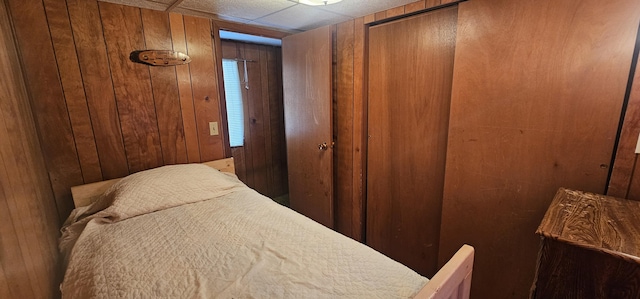 bedroom with wood walls and a closet