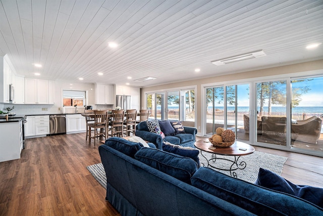 living room with dark hardwood / wood-style flooring, wooden ceiling, and a water view