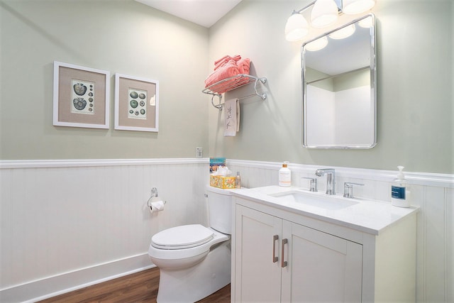 bathroom featuring vanity, wood-type flooring, and toilet