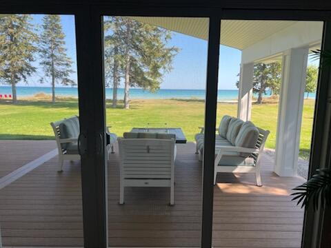 exterior space featuring a water view, hardwood / wood-style floors, and a view of the beach