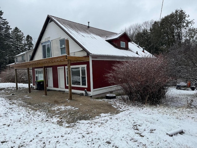 view of snow covered back of property