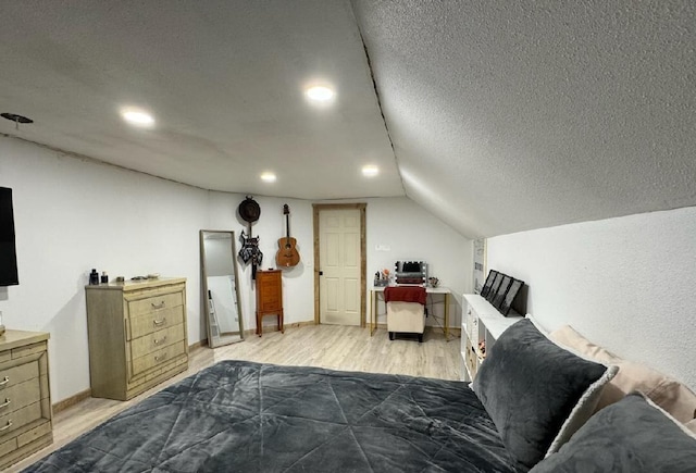 bedroom featuring a textured ceiling, light hardwood / wood-style floors, and vaulted ceiling