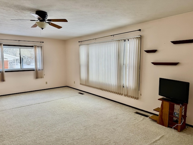 unfurnished living room featuring carpet, a textured ceiling, and baseboards