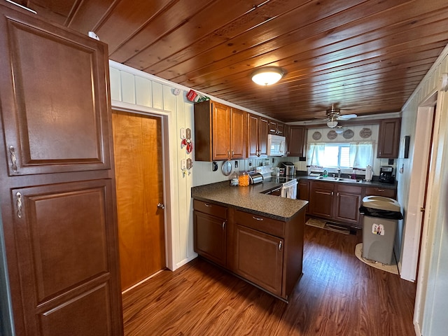 kitchen with dark hardwood / wood-style floors, stainless steel electric range oven, sink, and kitchen peninsula