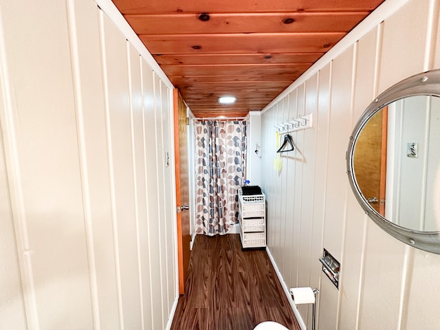 corridor featuring dark hardwood / wood-style floors, wooden ceiling, and wood walls