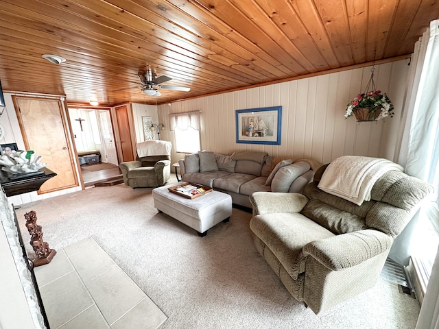 living room with ceiling fan, wooden ceiling, carpet floors, and wooden walls