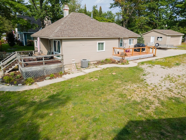 back of property with a yard, central air condition unit, and a wooden deck