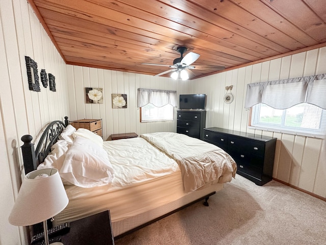 bedroom featuring ceiling fan, wood walls, light colored carpet, and wood ceiling