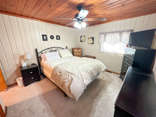 bedroom with light colored carpet, ceiling fan, wood walls, and wood ceiling