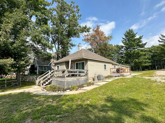 back of house with a yard, a wooden deck, and central AC