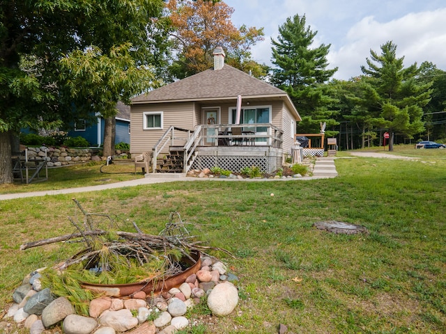 view of front of home with a wooden deck and a front lawn