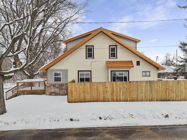 snow covered rear of property featuring a deck