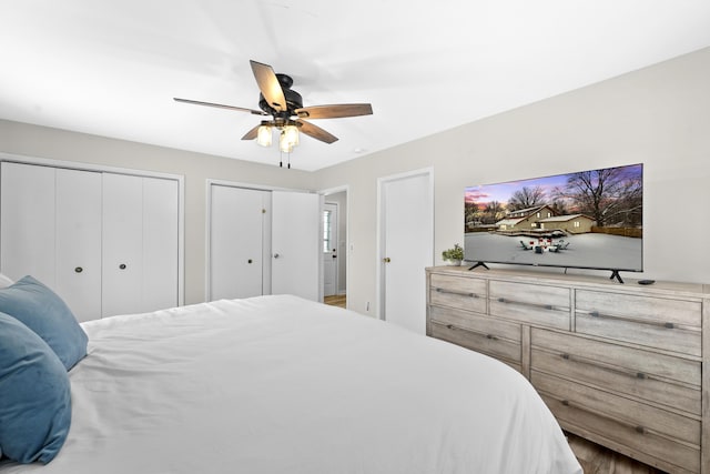 bedroom with ceiling fan and multiple closets