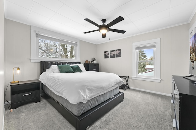 carpeted bedroom featuring ceiling fan and crown molding